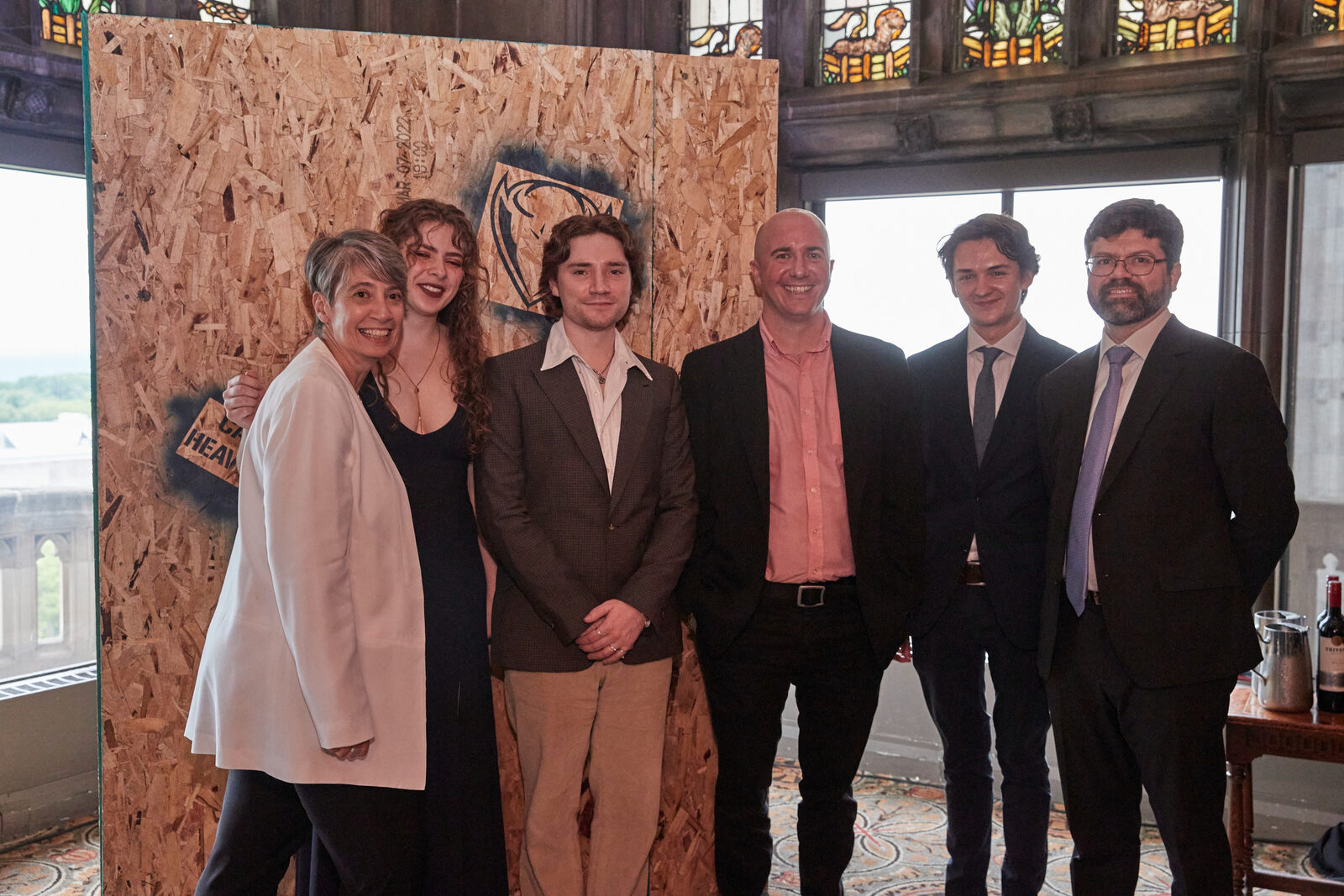 The student team that built the arcade cabinet, with Jay, in front of a plywood backdrop