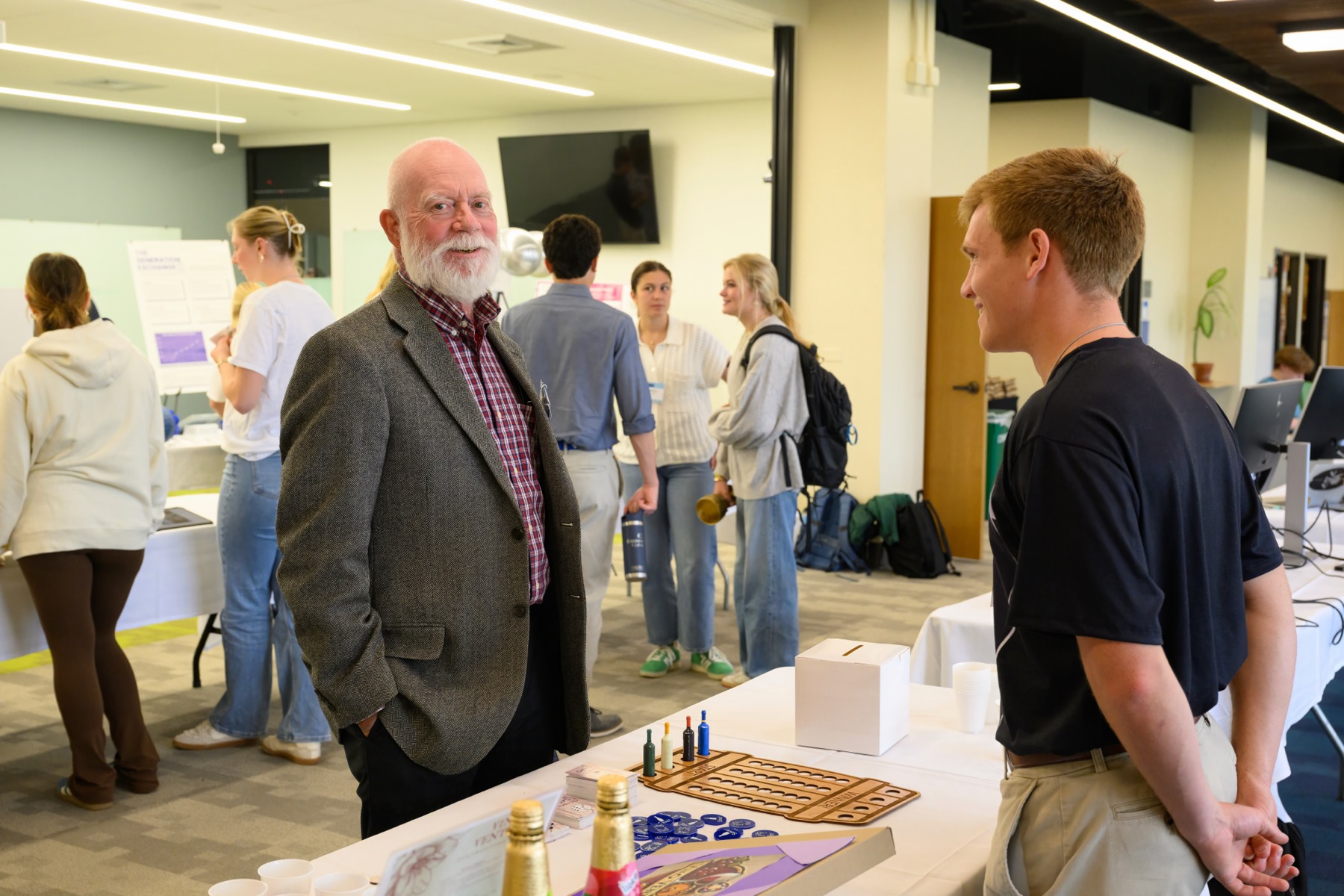 A student talking with a visitor at a poster at the Entrepreneurship Summit