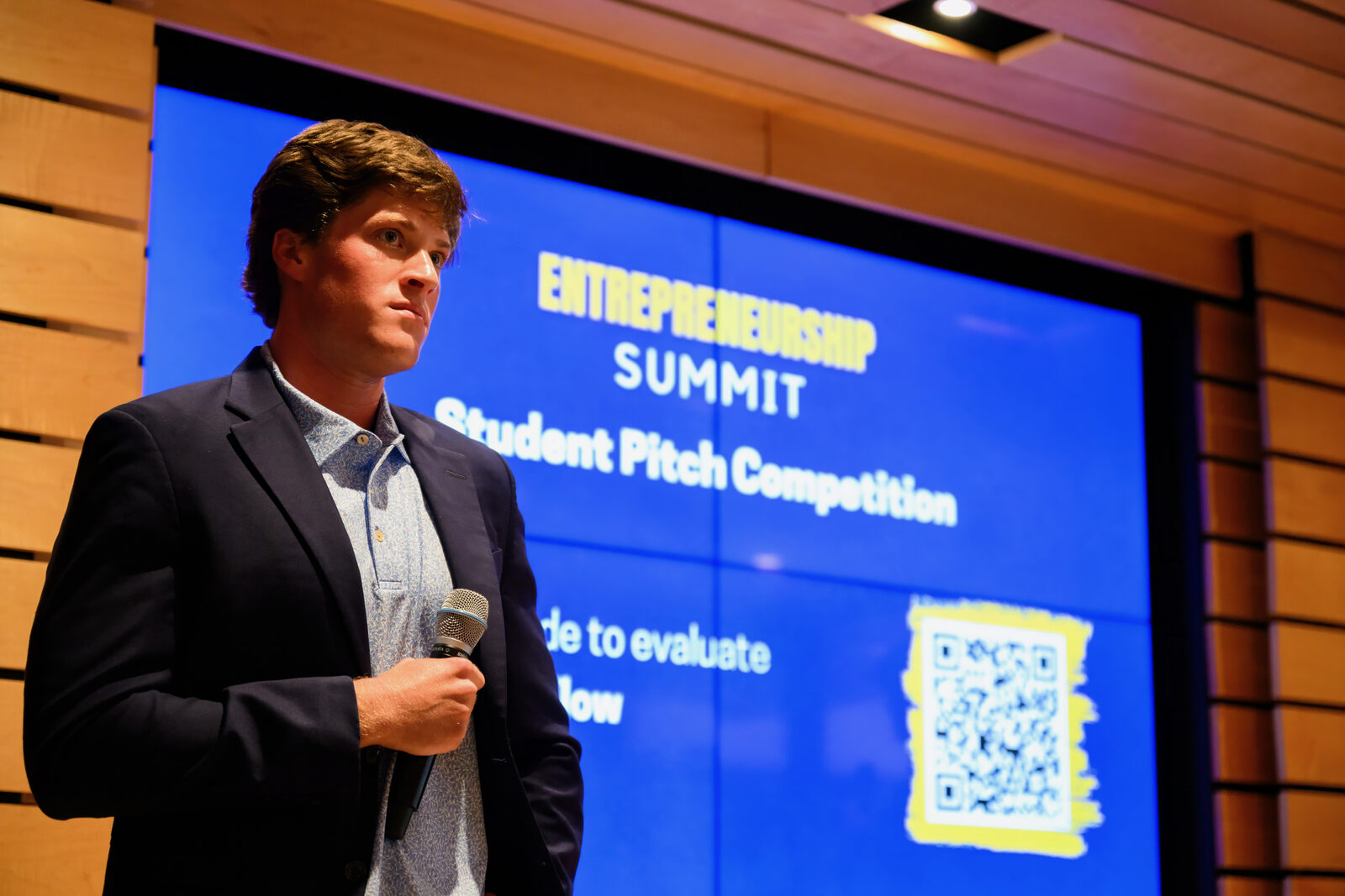 Two students pitching on stage at the Entrepreneurship Summit