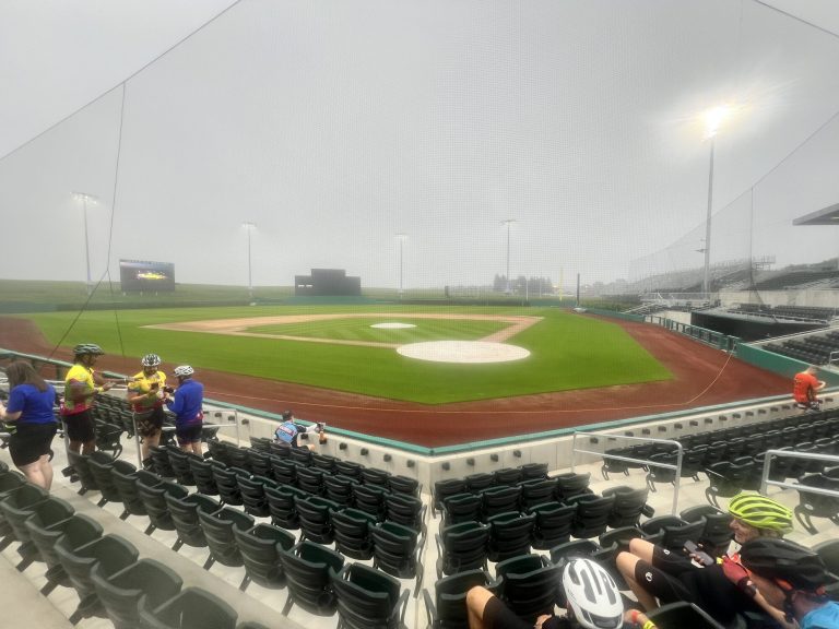 The MLB stadium at the Field of Dreams, in the mist, full of bike helmets.